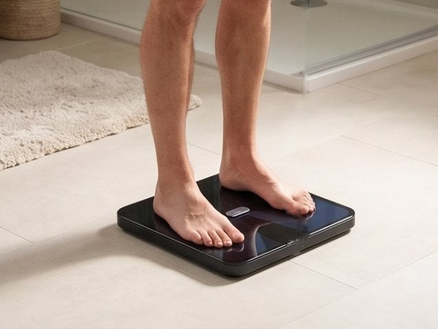 Person standing barefoot on the scale, feet on the electrodes